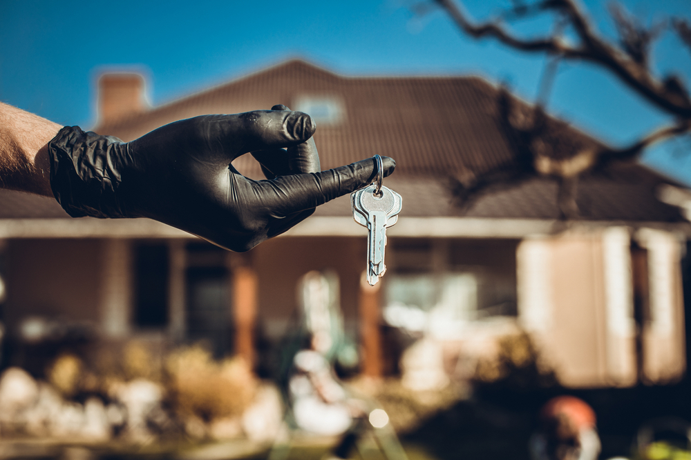 gloved hand holding key to new home
